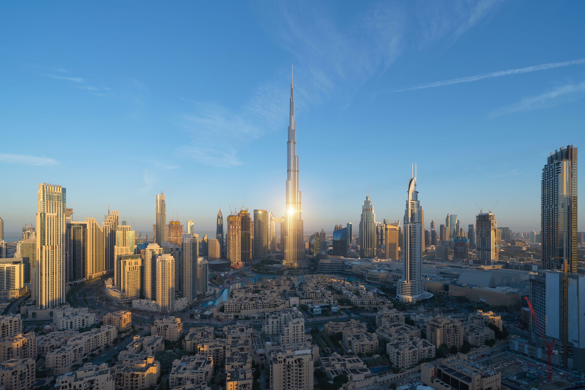 Aerial view of Burj Khalifa in Dubai Downtown skyline and fountain, United Arab Emirates or UAE. Financial district and business area in smart urban city. Skyscraper and high-rise buildings at sunset.