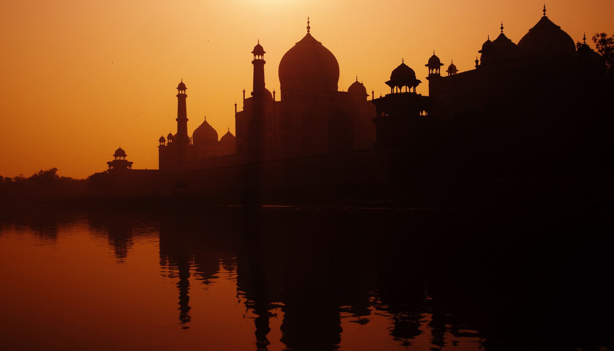 Sunset silhouette of a grand Taj Mahal.