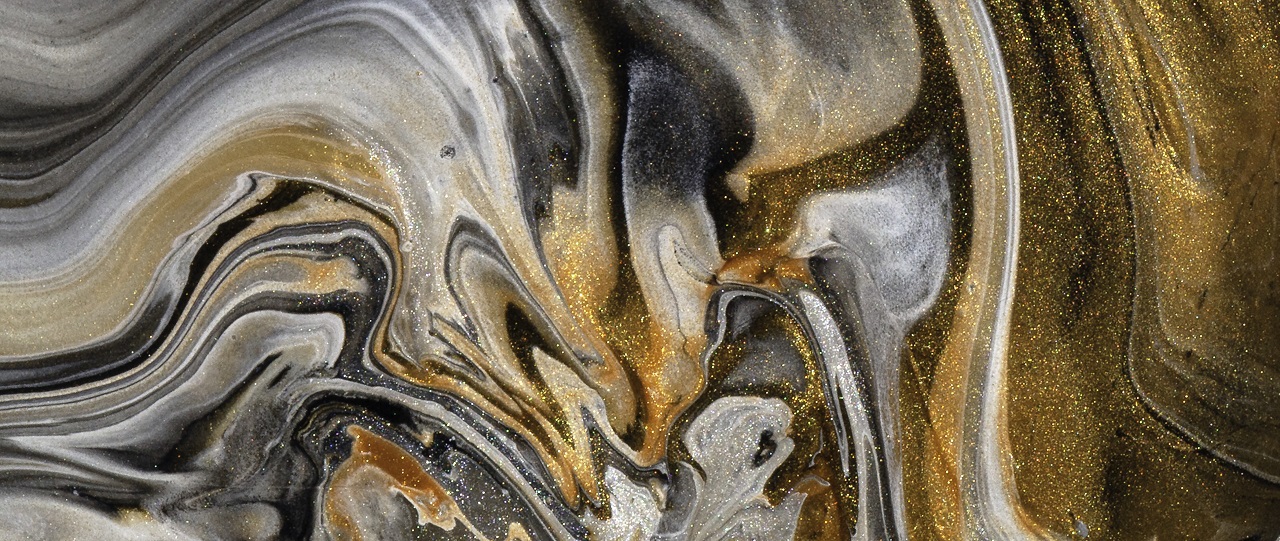 Close up of golden metallic acrylic paint in a thick swirl. Sparkles in the paint give an extra glow. Macro detail photo of my acrylic pouring work. 