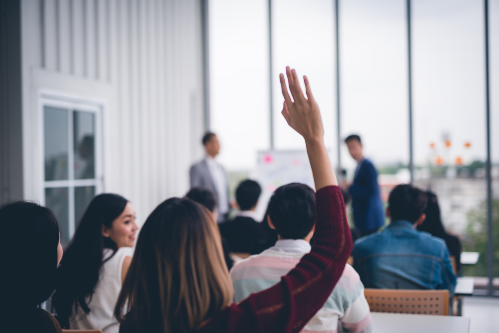 Woman raised up hands and arms  in seminar class room to agree with speaker at conference seminar meeting room 