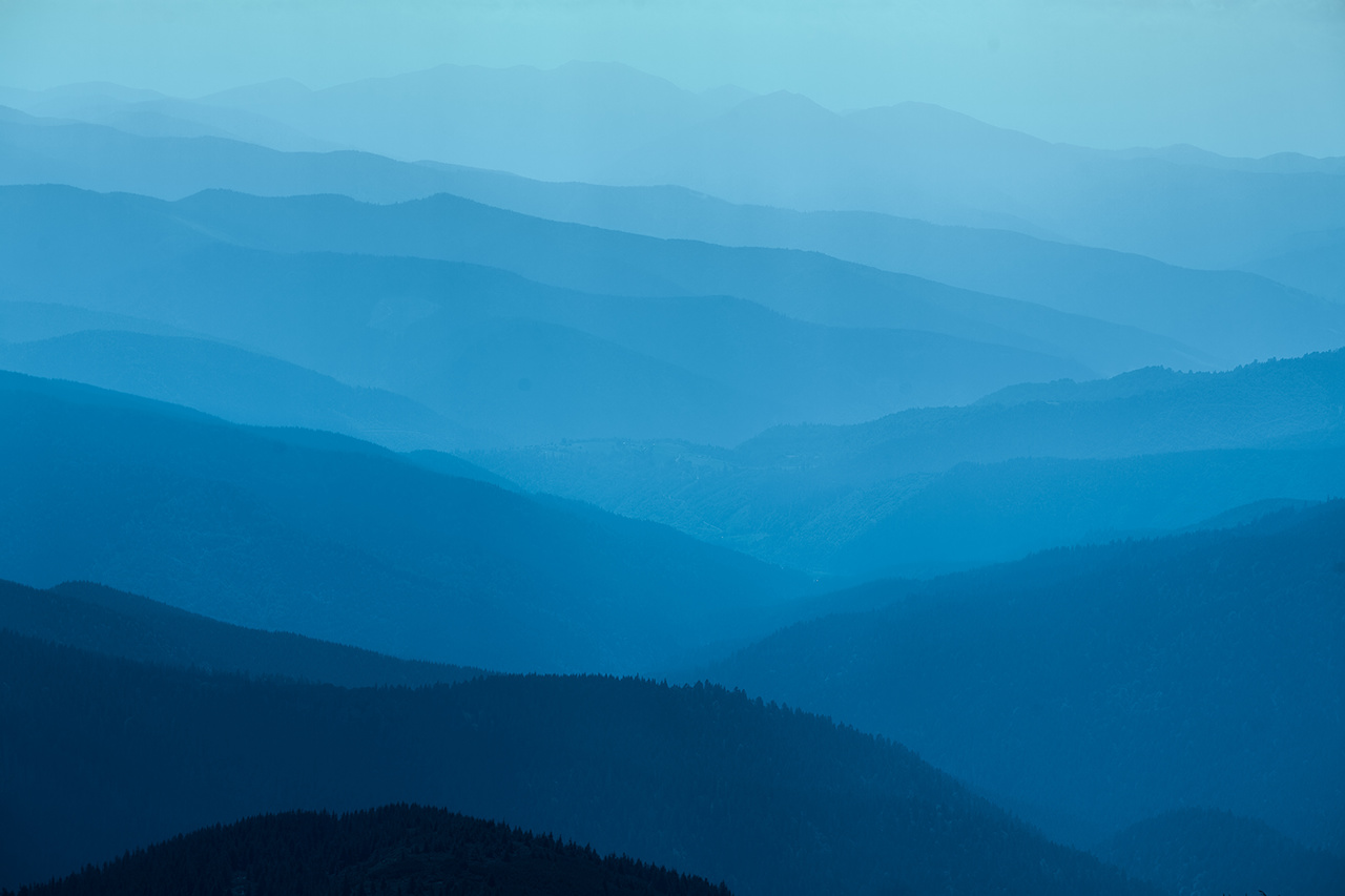 Abstract mountain background - concept of tourism and mountaineering. Layers of ridges in Carpathians Mountains Ukraine at sanrise sky