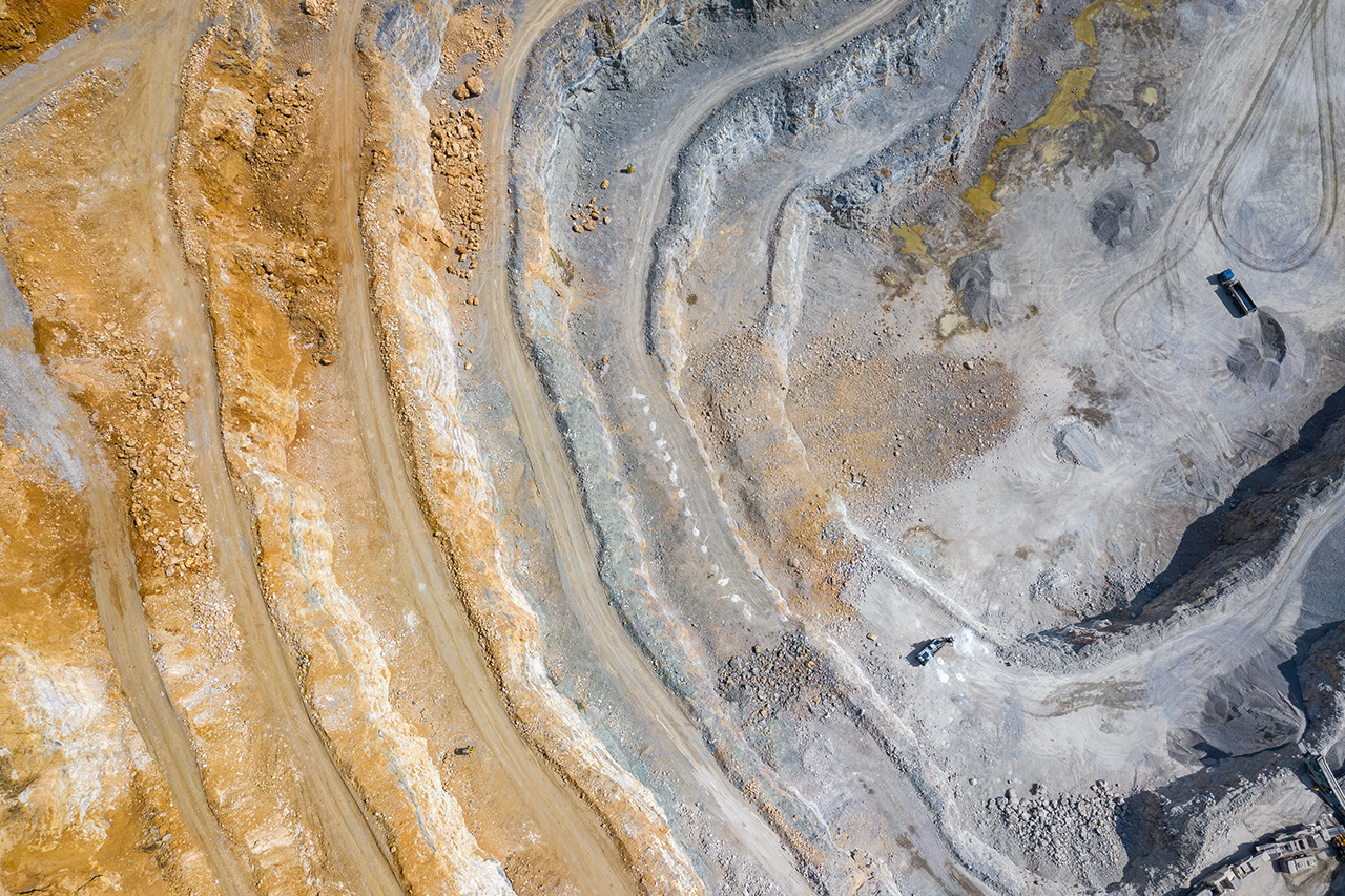 Mining from above. Industrial terraces on open pit  mineral mine. Aerial view of opencast mining. Dolomite Mine Excavation. Extractive industry. Giant excavator machinery.