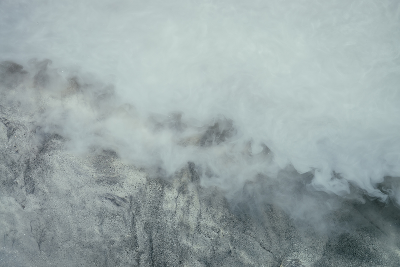 Nature background of silver water of mountain river. Silver sand on sandy bottom of mountain river. Gray ripples on milky river surface. Gray nature texture of clear water with sand. Natural backdrop.