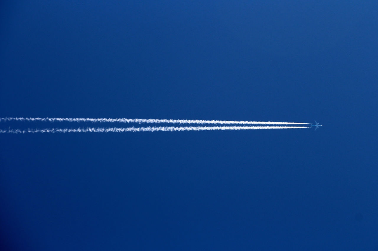 Low Angle View Of Airplane Against Clear Blue Sky
