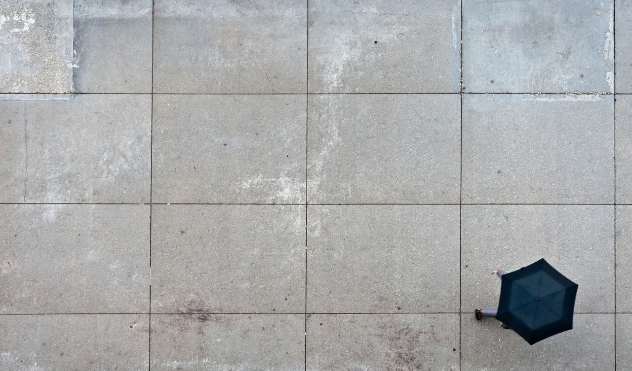 Person with Black Umbrella on Wet Street