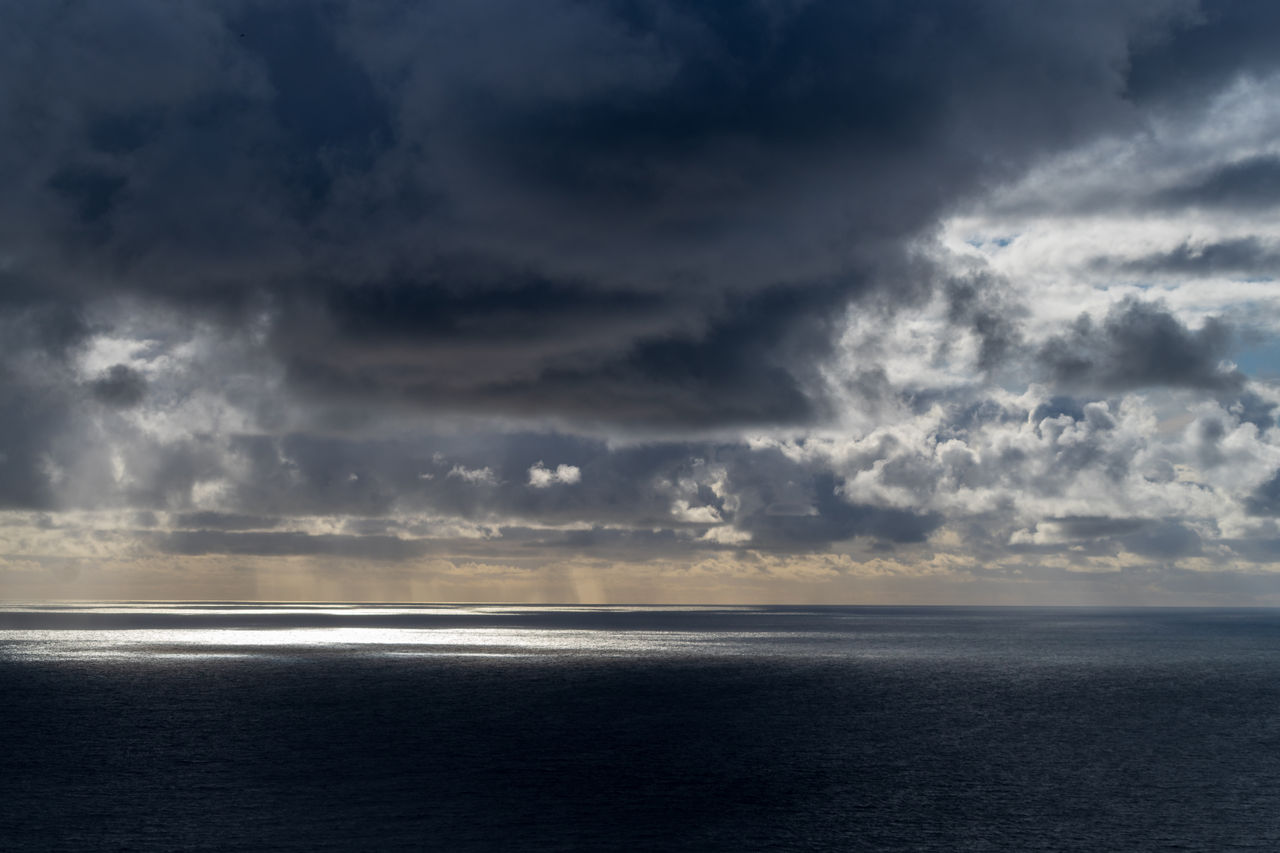 sun breaking through dark clouds over the Atlantic Ocean seen from the Irish coast in spring at the cliffs of moher, sun breaking through dark clouds over the Atlantic Ocean seen fr