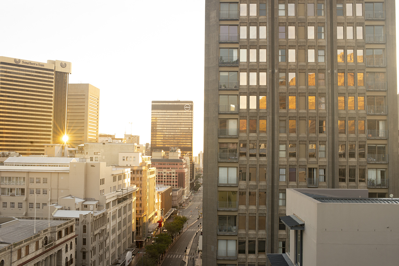 Sunset over buildings in city center Cape Town South Africa with reflections of table mountain in window