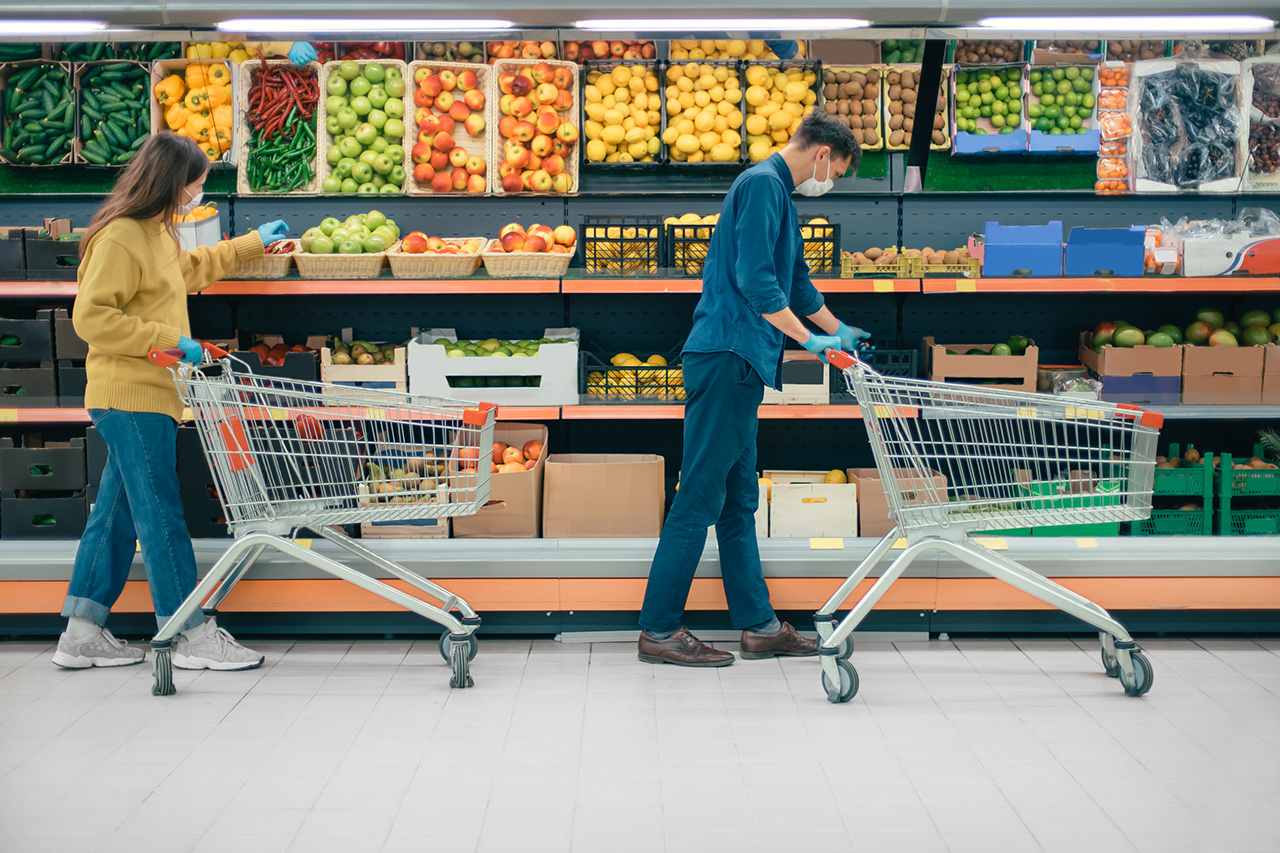 man and a woman with shopping carts in a supermarket during the quarantine period. photo with a copy-space
