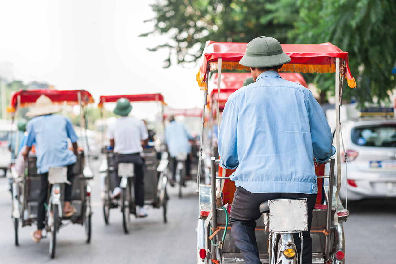 Traditional cyclo ride down the streets of Hanoi, Vietnam. The cyclo is a three-wheel bicycle taxi that appeared in Vietnam during the French colonial period.