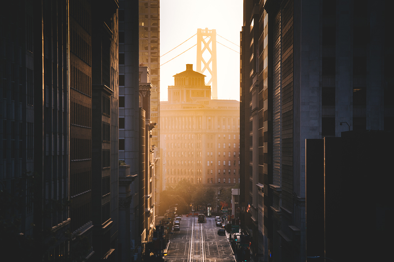 Downtown San Francisco with famous California Street illuminated in first golden morning light at sunrise in summer, San Francisco, California, USA