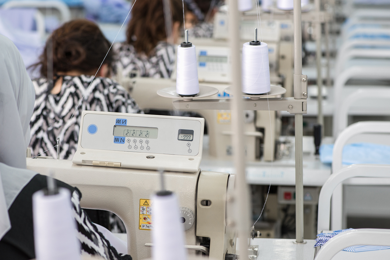 women in the textile factory. workers in the sewing workshop working on a sewing machine