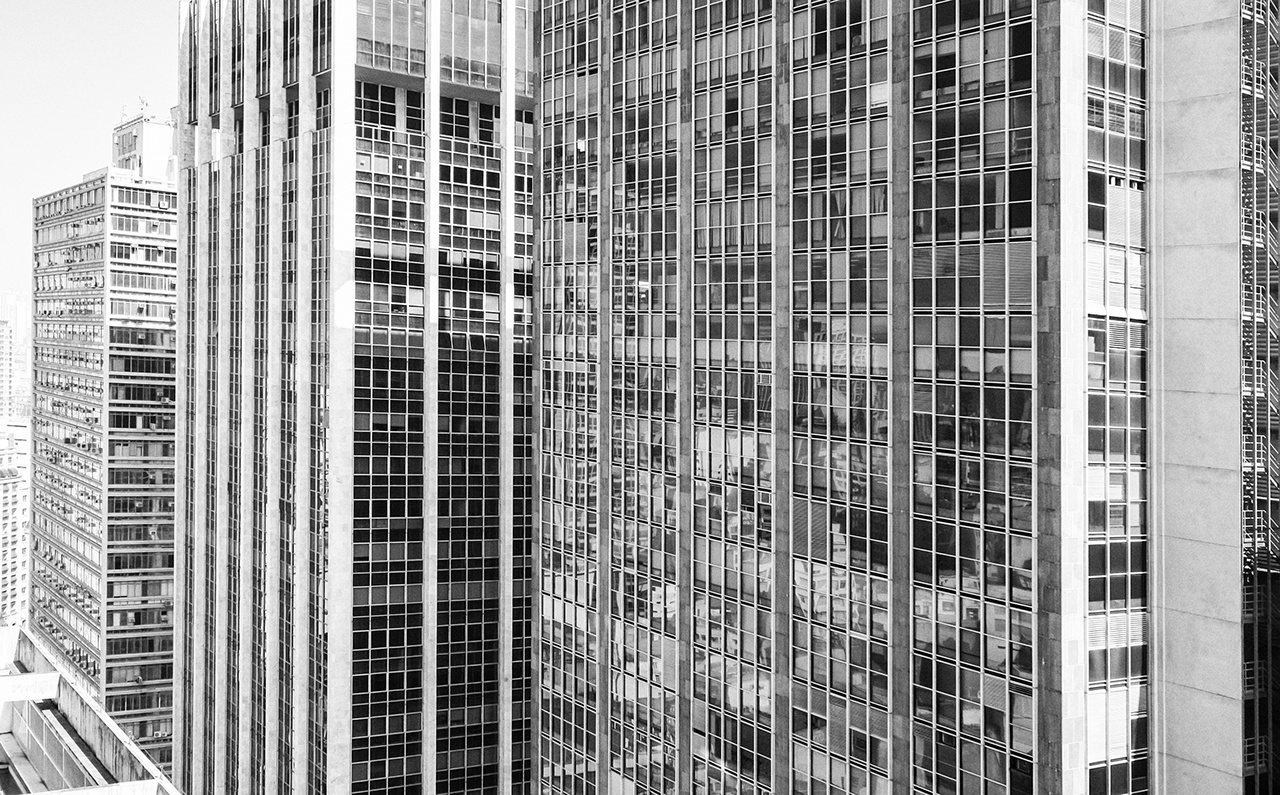 Prédio cheio de janelas, com reflexo sem pessoas. Centro urbano de São Paulo, Brasil.