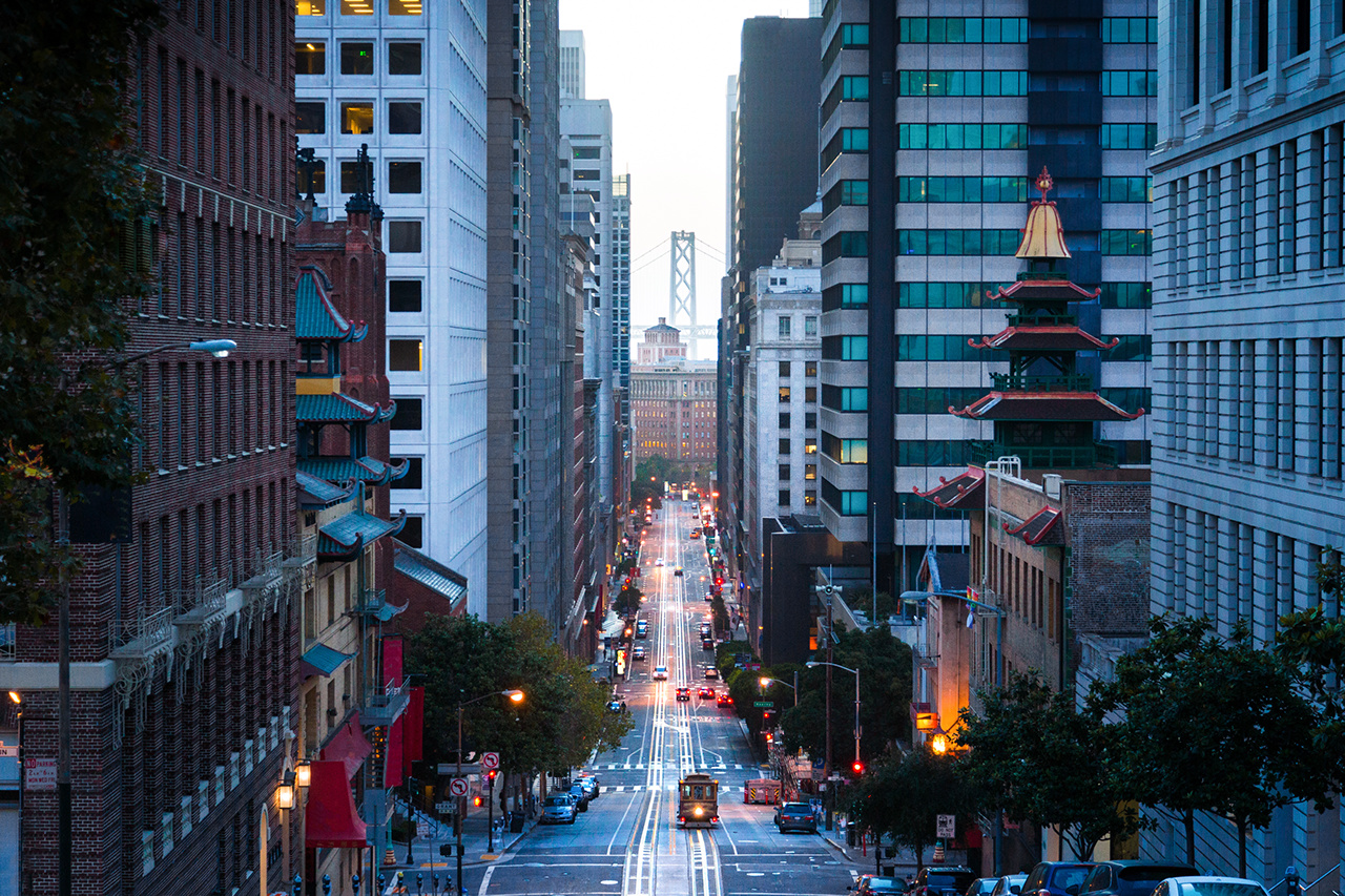 Classic view of downtown San Francisco with cable car on California Street with famous Oakland Bay Bridge in the background at dawn, San Francisco, California, USA