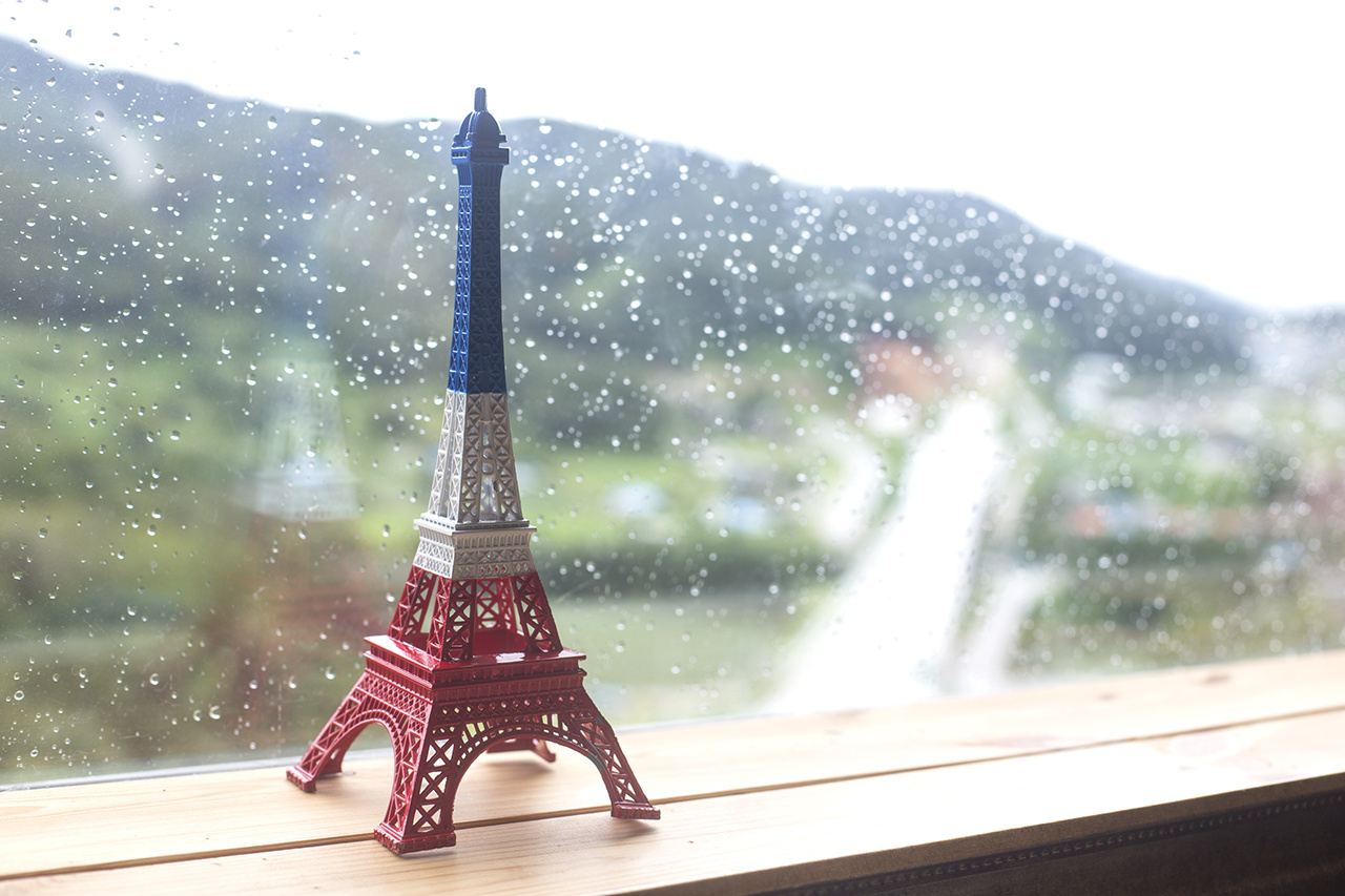 Eiffel tower miniature by the window. rainy day