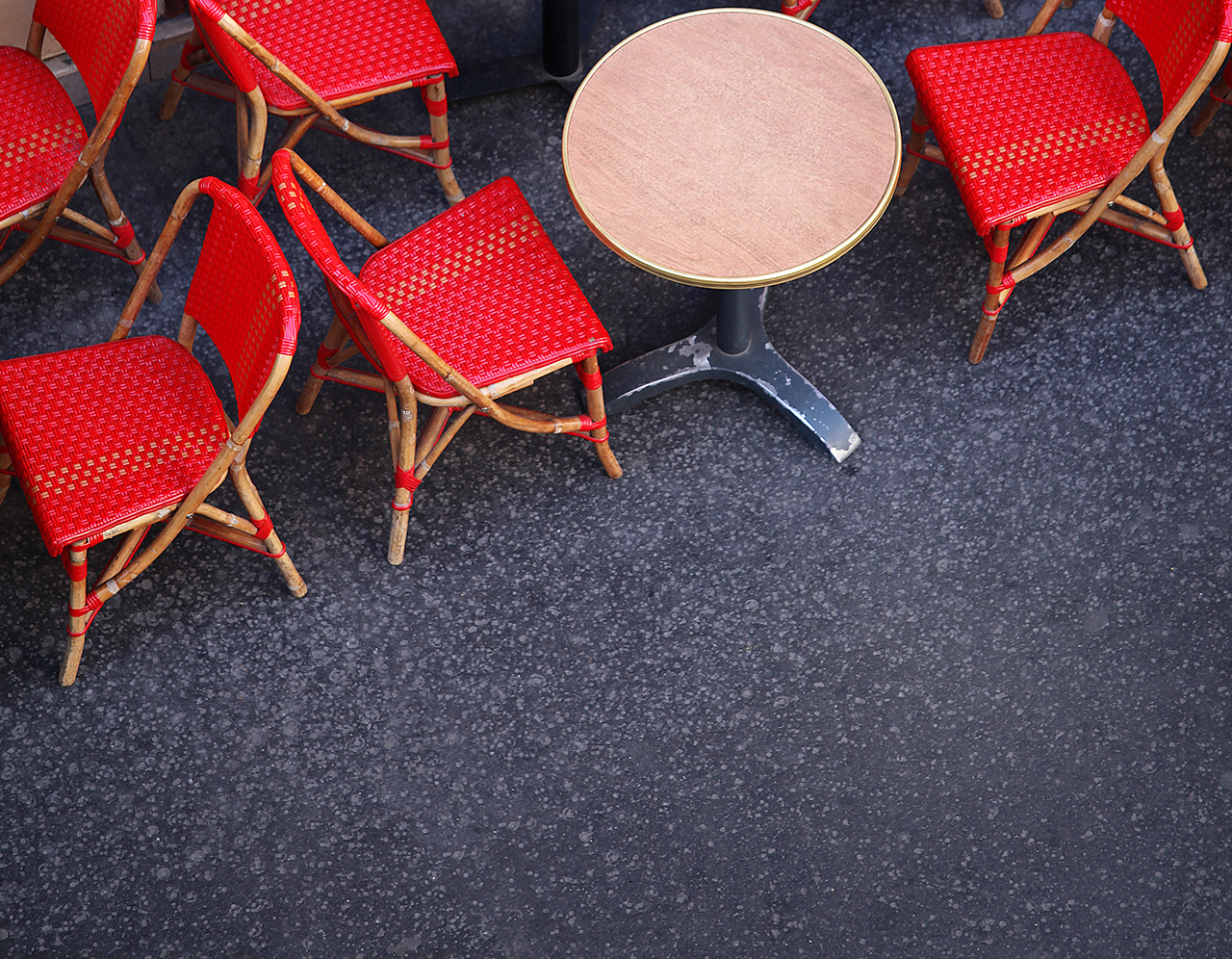 rote Stühle vor einem Bistro